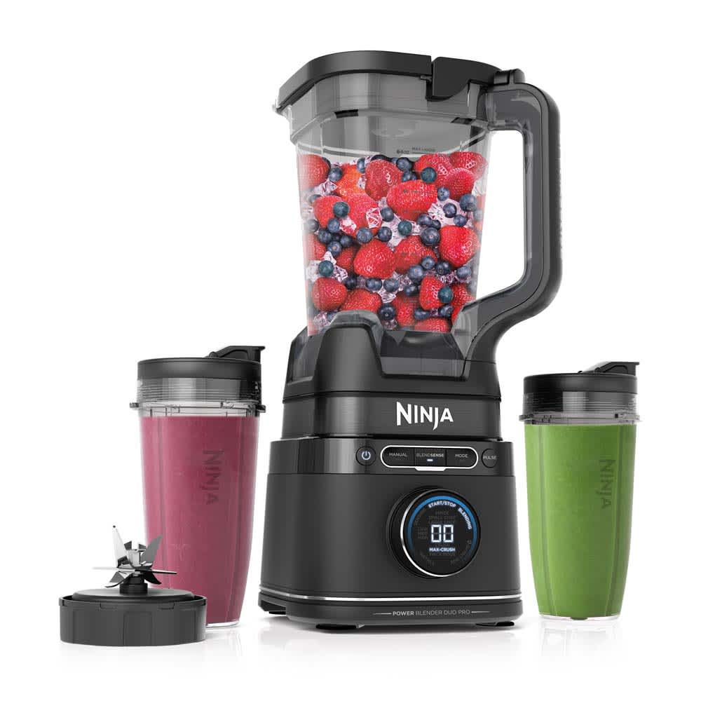The exact TB301 main asset shows the black base, pitcher, two clear personal cups with spout lids, and the separate Hybrid Edge blade assembly; food is staged within both vessels